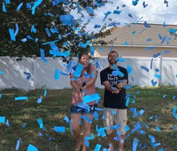 Pink biodegradable confetti cascade at gender reveal party